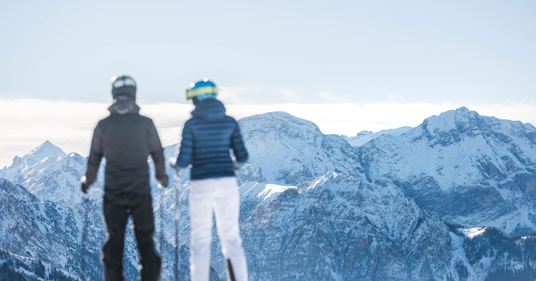 Two people on ski enjoy the view on the mountains